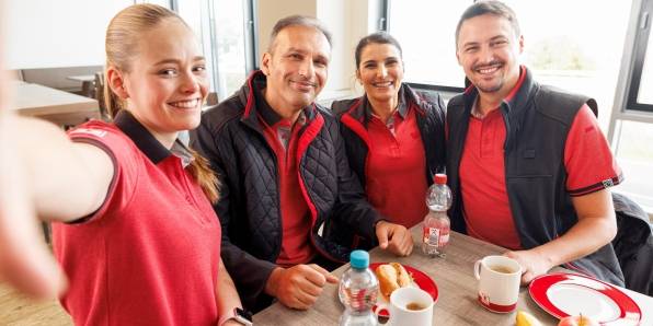 Selfie-Gruppenbild vom Kaufland-Logistiksteam im Pausenraum.