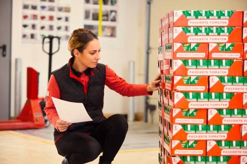 Im Lager einer Kaufland-Filiale: Verkaufsmitarbeiterin überprüft eine Paletten-Ladung Tomaten-Tetrapaks.