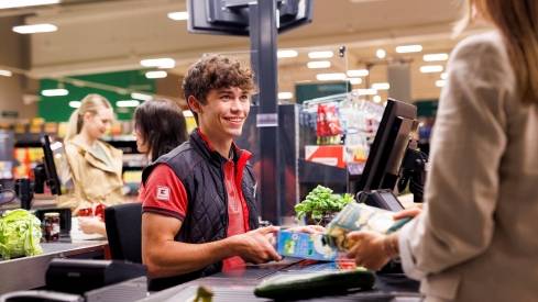 An der Kasse in einer Kaufland-Filiale: Junger Mitarbeiter kassiert den Einkauf einer Kundin.